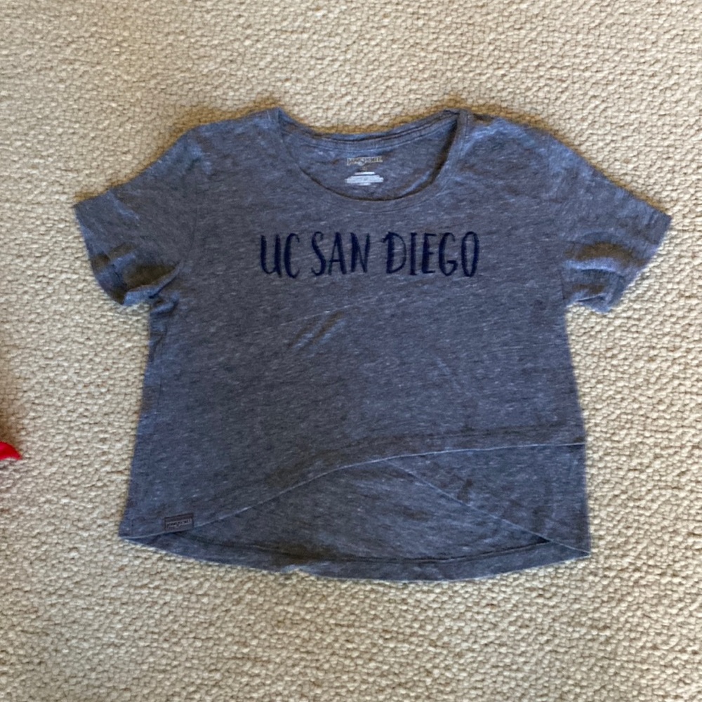 Jansport soft grey T-shirt.  Cropped cross over front longer in back.  Size M.